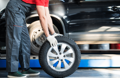 Tire rotation guide - mechanic installing a tire on a car